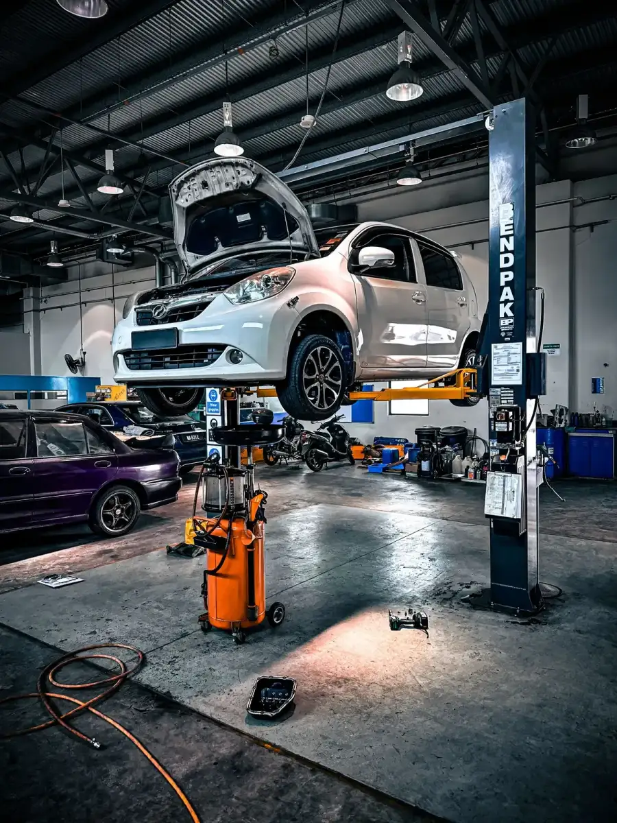 A car raised on a two-post lift in a garage workshop
